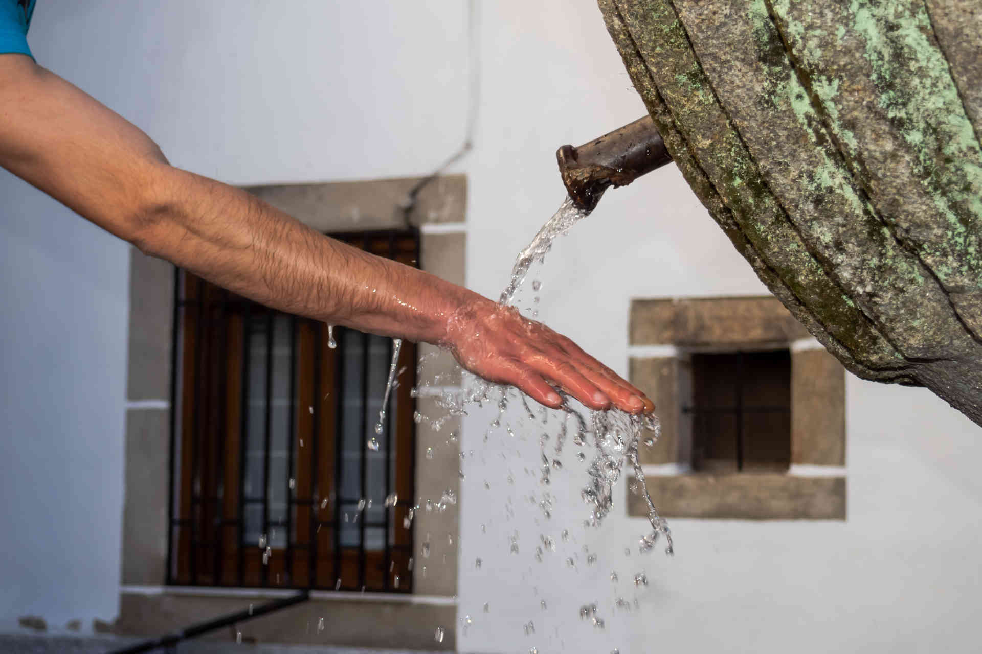 uomo-che-si-bagna-una-mano-a-una-fontana